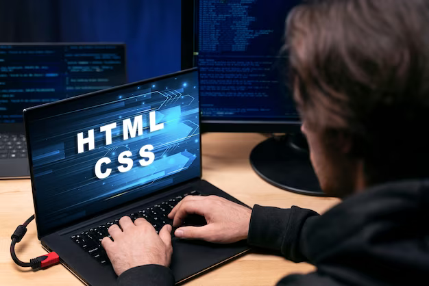 Man working on laptop with HTML CSS inscription