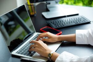 Close up of female hands typing on keyboard of laptop